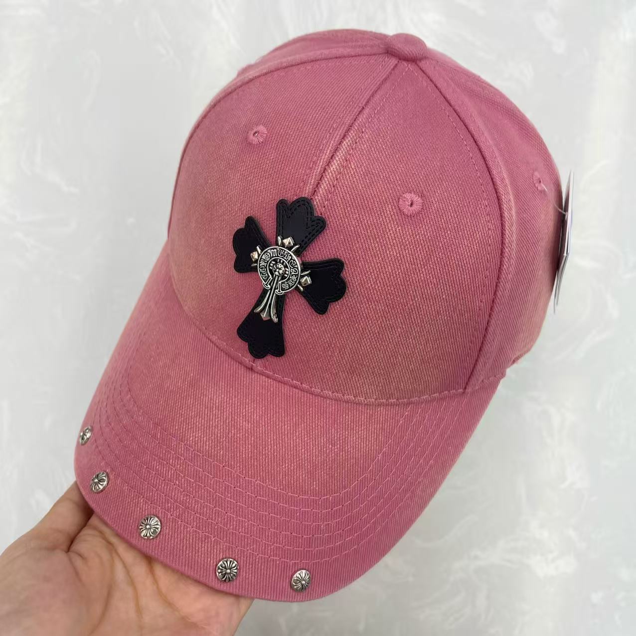 Close-up of floral concho rivet row along brim edge of washed cotton baseball cap